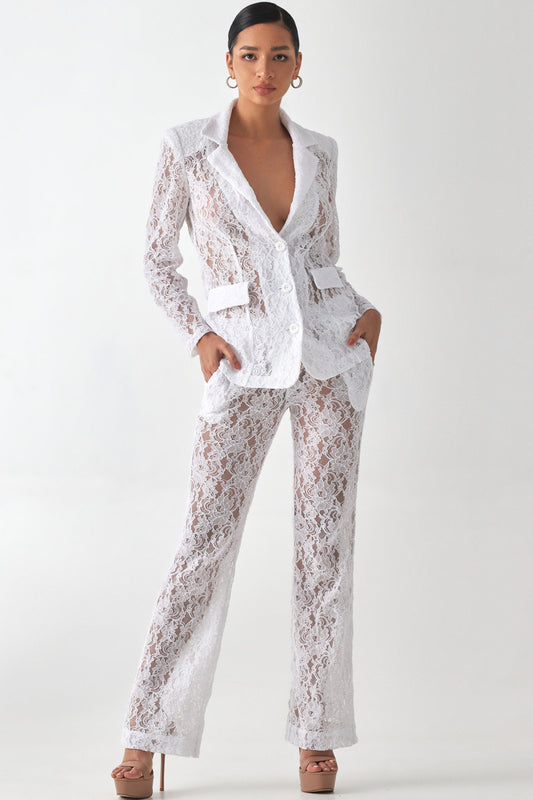 A female model wearing a white lace pant suit with a single button, button-up front zipper closure, and side pockets.