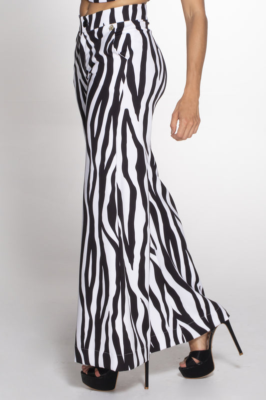 A model wearing a pair of wide-leg pants with a zebra animal print.